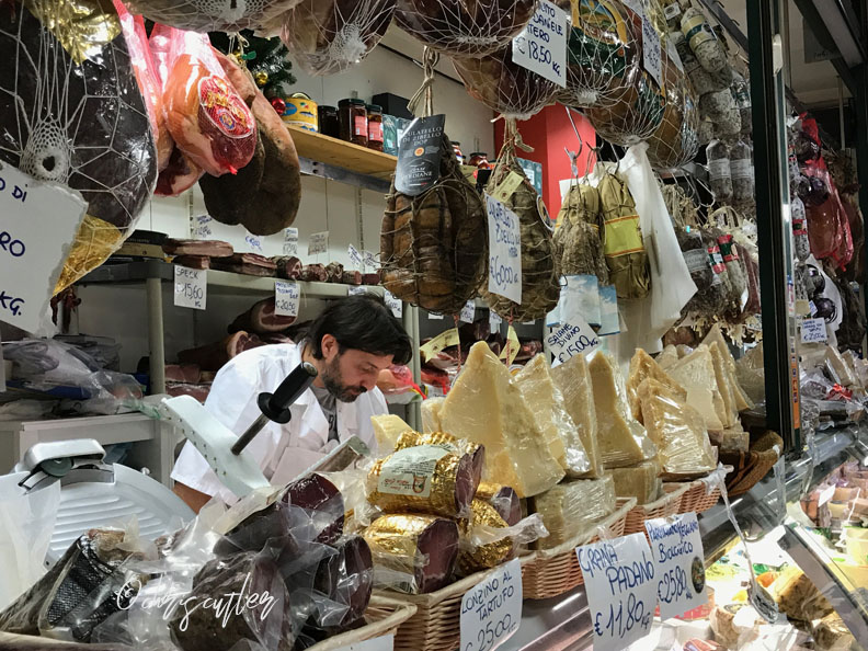 man surrounded by cheese and proscuitto