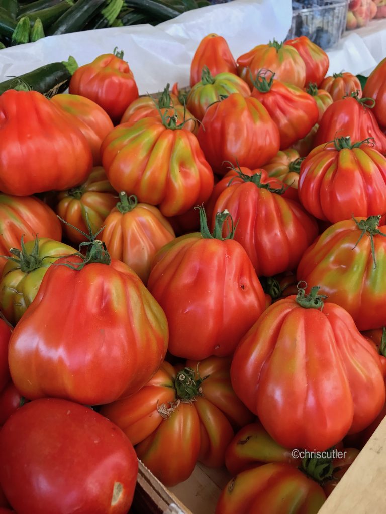 Italian markets: box of red tomatoes at produxe stall at Mercato delle Erbe Bologna.