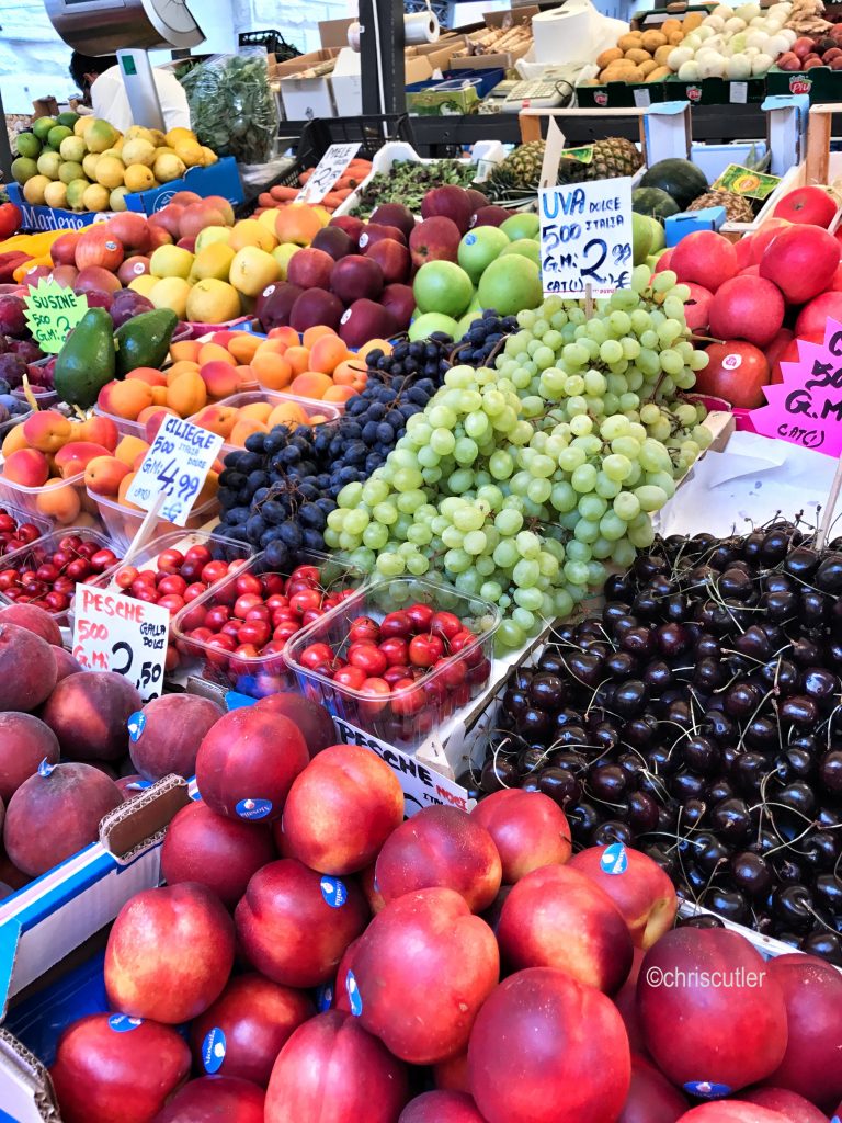 Boxes of grapes, strawberries, peaches, plums