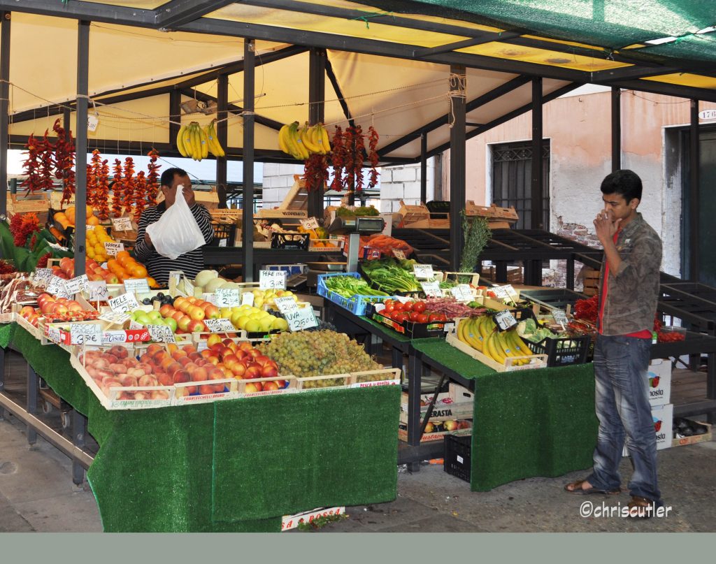 Man standing near boxes of fruit and vegetaaables