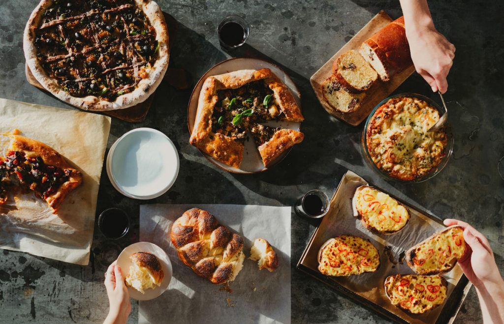 flatlay of a variety of breads and pizza