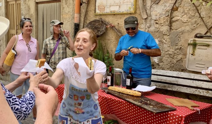 Rural Tourism and Experiential Travel in Sicily: woman handing out food to tourist