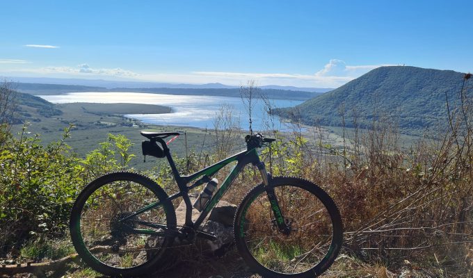 Via Francigena - bicycle on mountain top overlooking valley and lake