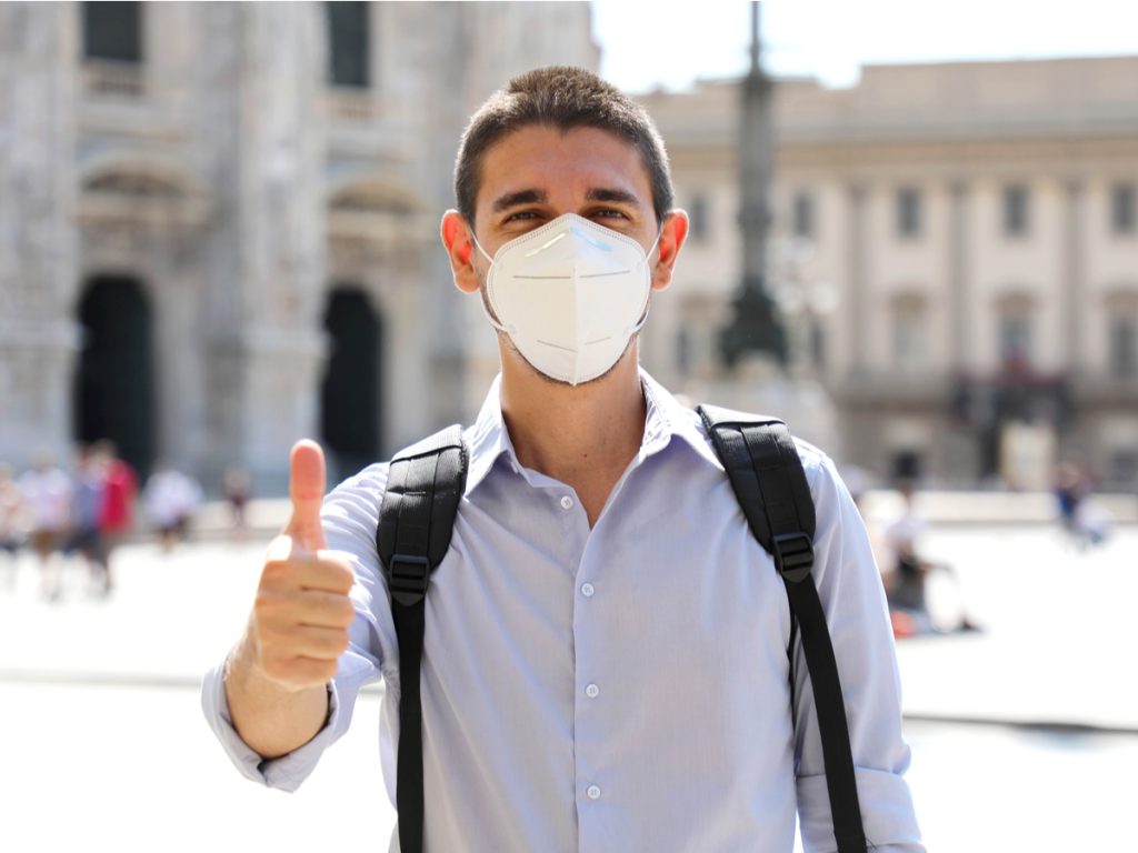 Traveling to Italy in 2022: young man with KN95 mask in Piazza.