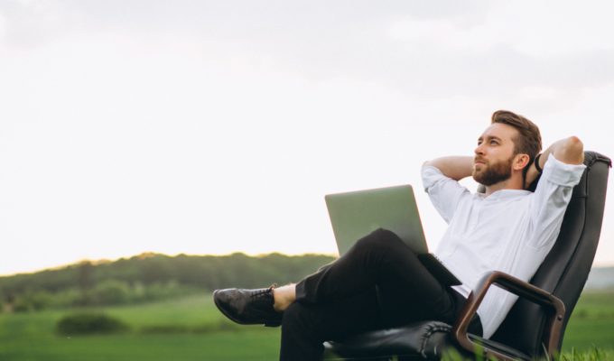 Digital Nomad Visa for Italy - man sitting with laptop in field