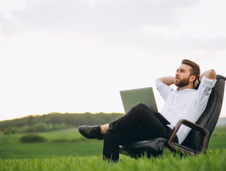Digital Nomad Visa for Italy - man sitting with laptop in field