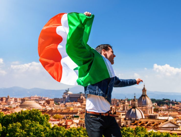 Visit Italy. Man holding Italian flag with Rome in the background