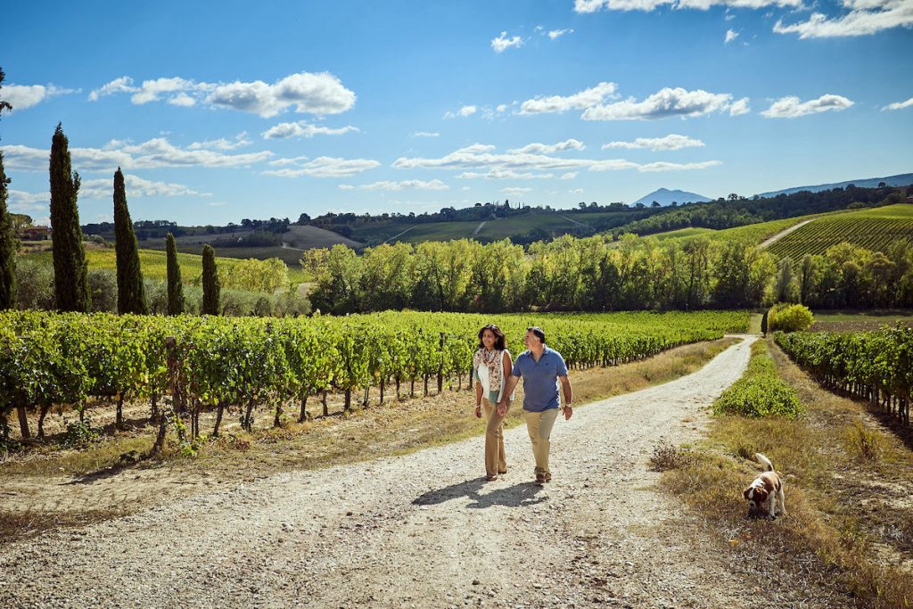 Poggio Golo - couple walking through vineyard in Tuscany