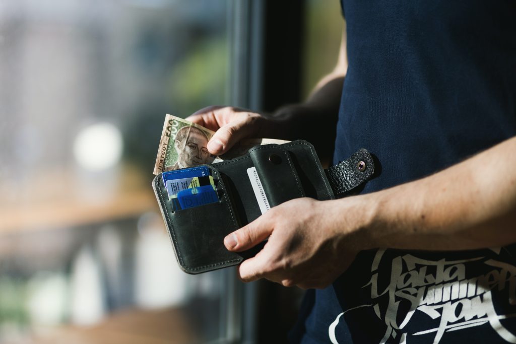 travel safety tips - man pulling money from wallet