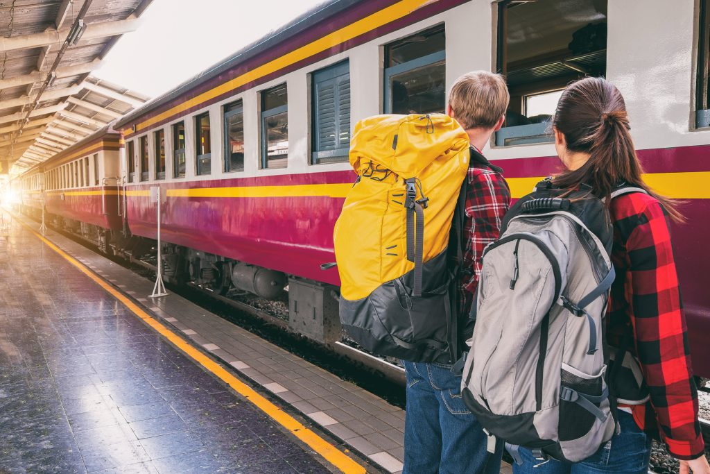 travel safety tips - travelers with backpacks at train station