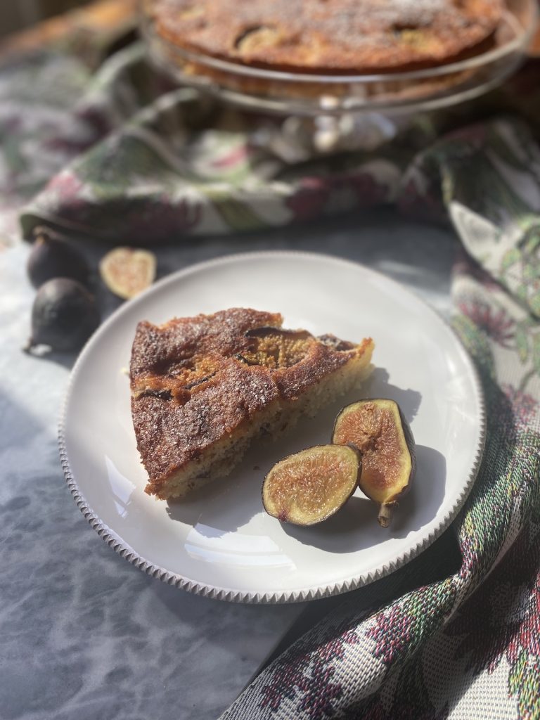 fig and almond cake with fresh figs on a white plate