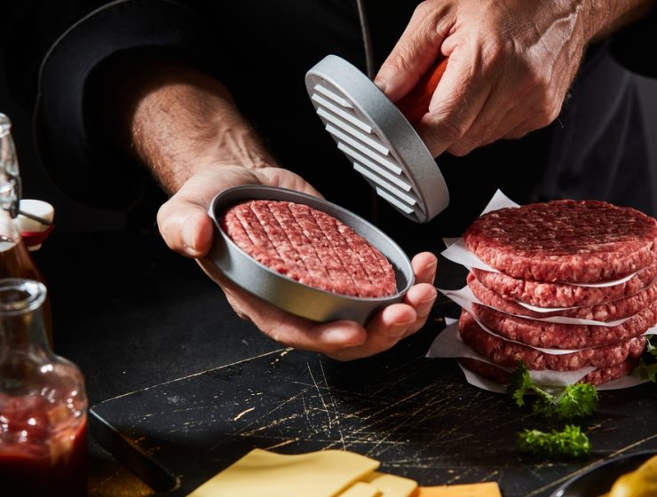 Fast Food Gourmet: Chef using a burger press to prepare fresh homemade ground beef patties