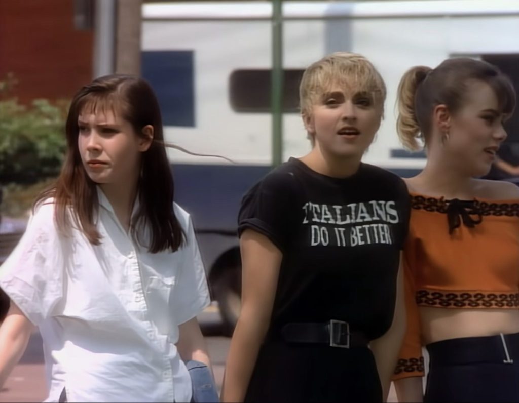 Still from "Papa Don't Preach" video, in which Madonna wears the "Italians Do It Better" t-shirt
