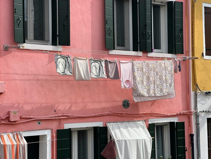Burano Italy - coloroful town with pink building and laundry hanging from window