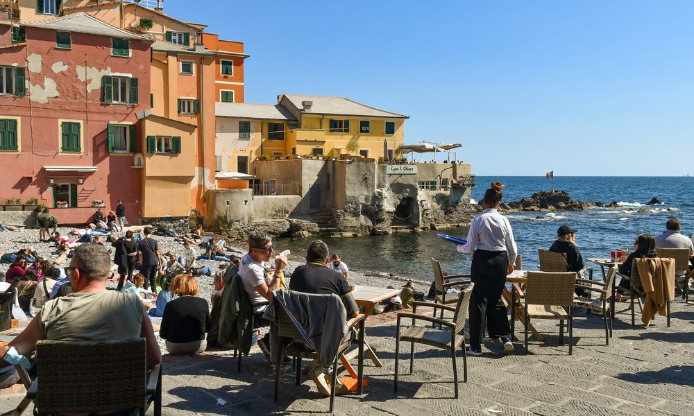 people sitting on beach in Liguria on Easter Monday Pasquetta