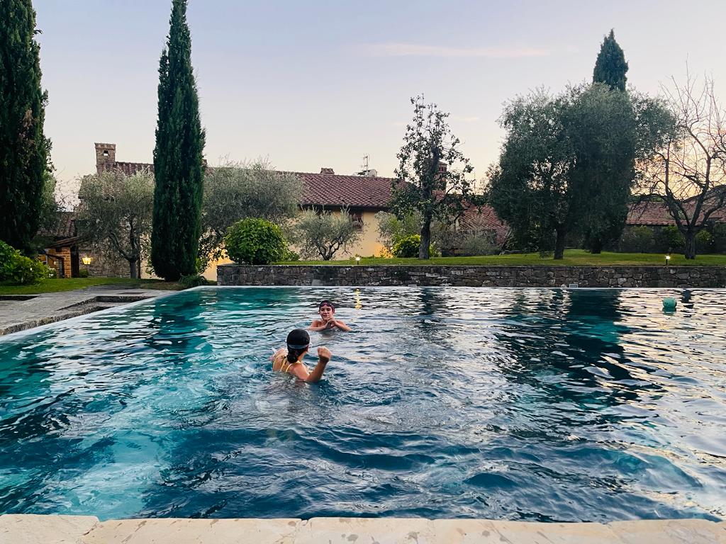 young children enjoying swimming in a pool outside of an Italian villa