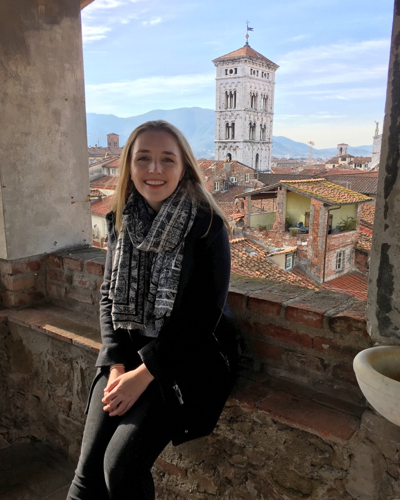 Lucca: young woman sitting in front of Lucca piazza