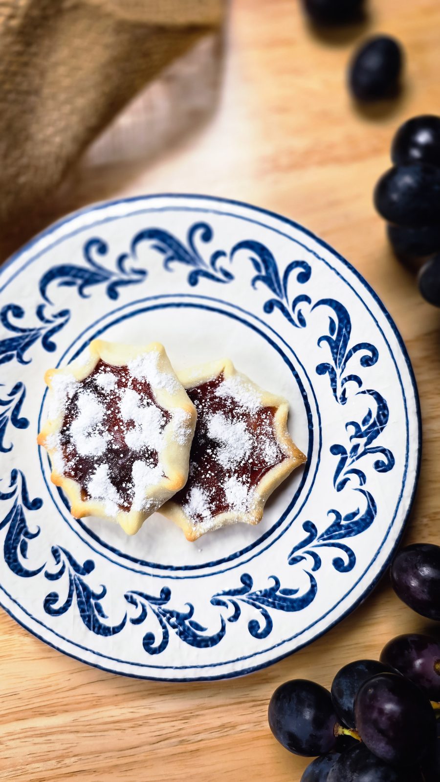 Pitteddhe - star shaped cookies on plate with grapes beside it