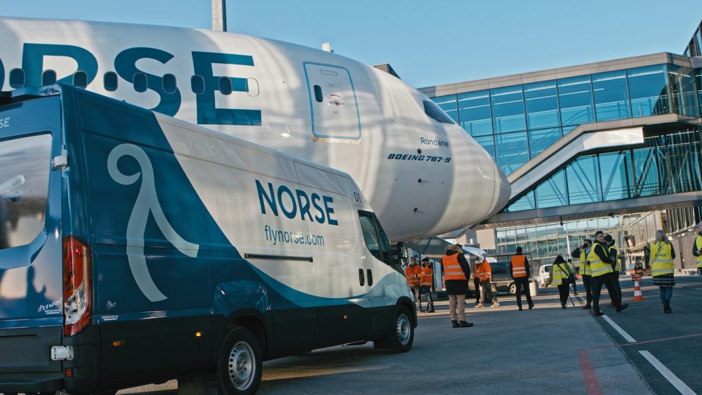 Norse Atlantic Airways plane parked at airport terminal.