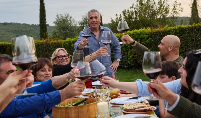author John Bersani with a group of friends in Tuscany eating food and drinking wine
