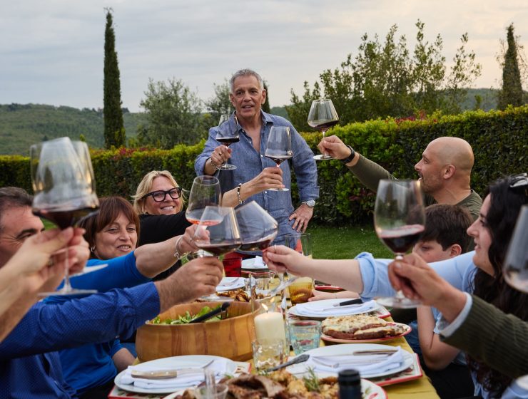 author John Bersani with a group of friends in Tuscany eating food and drinking wine
