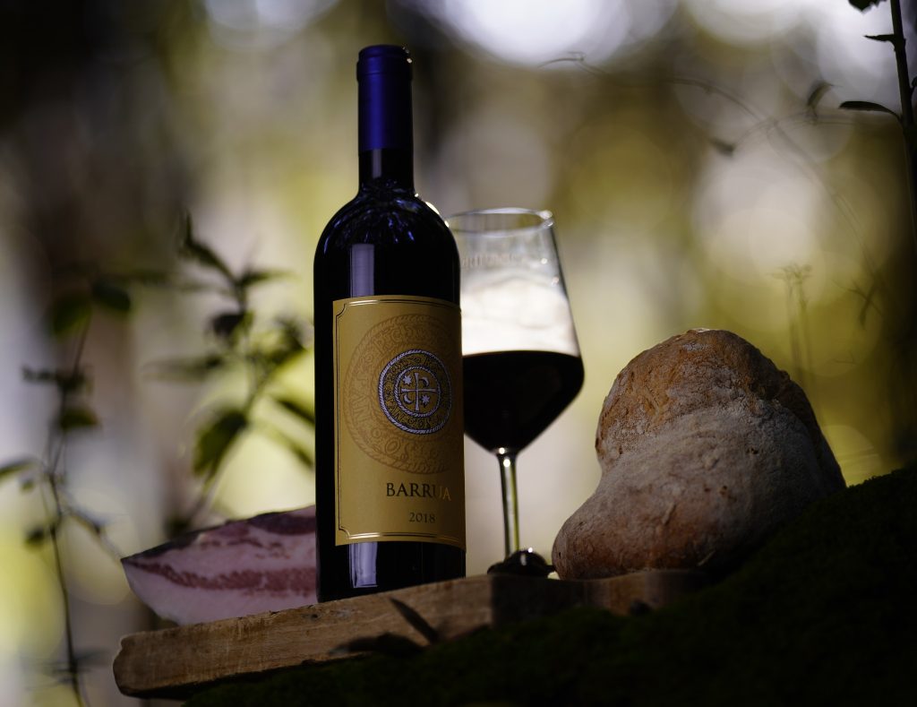 Barrua bottle of wine with glass and guanciale outside