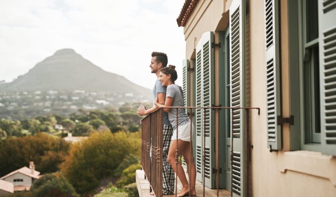 moving to Italy - young couple on balcony overlooking Italy landscape