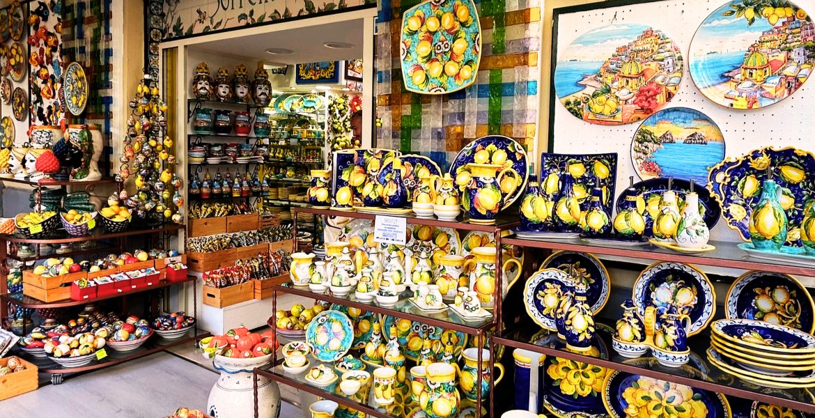 A vibrant storefront of a pottery shop in Sorrento, Italy, named Sorrento È, with handcrafted ceramics displayed outside.