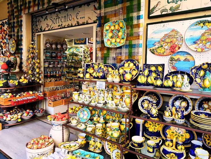 A vibrant storefront of a pottery shop in Sorrento, Italy, named Sorrento È, with handcrafted ceramics displayed outside.