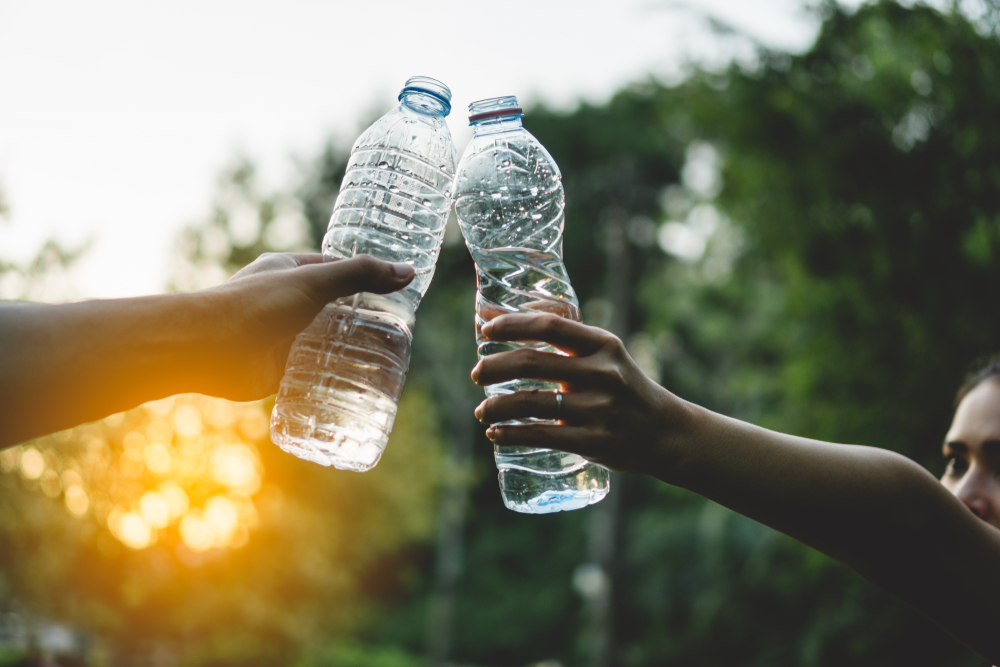 toasting with water bottles in nature - healthy lifestyle