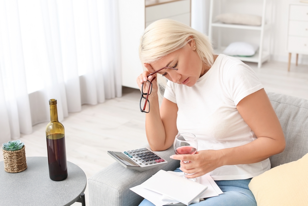 woman worrying about economy holding wine glass