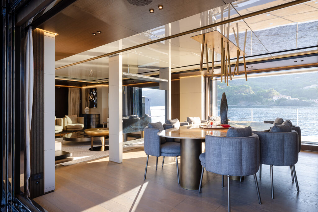 Dining area inside a Rossinavi yacht overlooking calm water, blending elegant design with a welcoming atmosphere