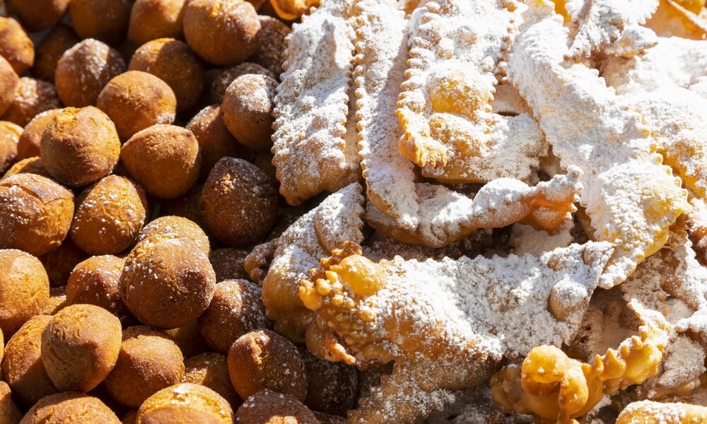 Frappe or chiacchiere and onbaked castagnole typical Italian carnival fritters dusted with powdered sugar. Biscuits with sugar for the carnival of Venice. Traditional sweet pastries of the carnival
