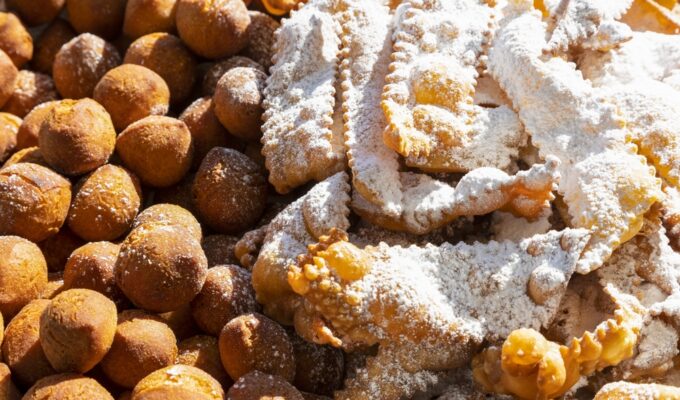 Frappe or chiacchiere and onbaked castagnole typical Italian carnival fritters dusted with powdered sugar. Biscuits with sugar for the carnival of Venice. Traditional sweet pastries of the carnival