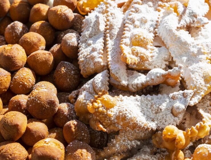 Frappe or chiacchiere and onbaked castagnole typical Italian carnival fritters dusted with powdered sugar. Biscuits with sugar for the carnival of Venice. Traditional sweet pastries of the carnival