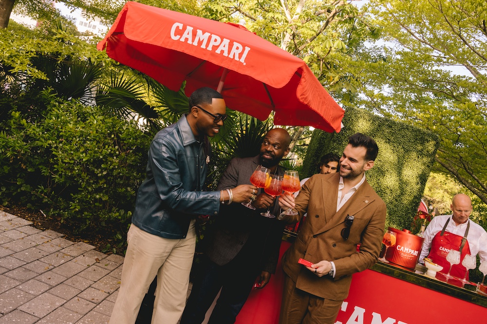 men enjoying Campari - clinking glasses and toast