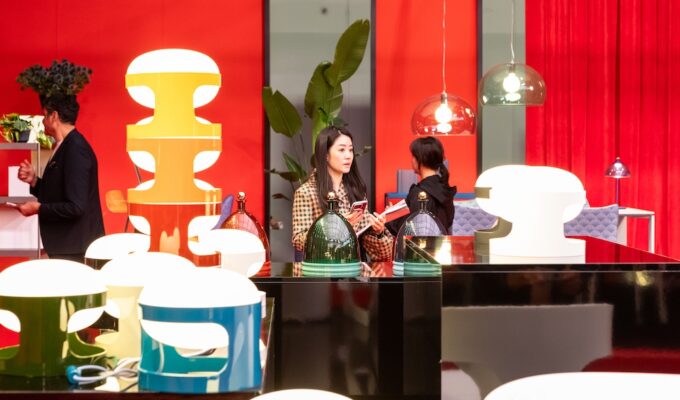 Salone del Mobile. Milano 2026 exhibitor booth with bright red and attendees