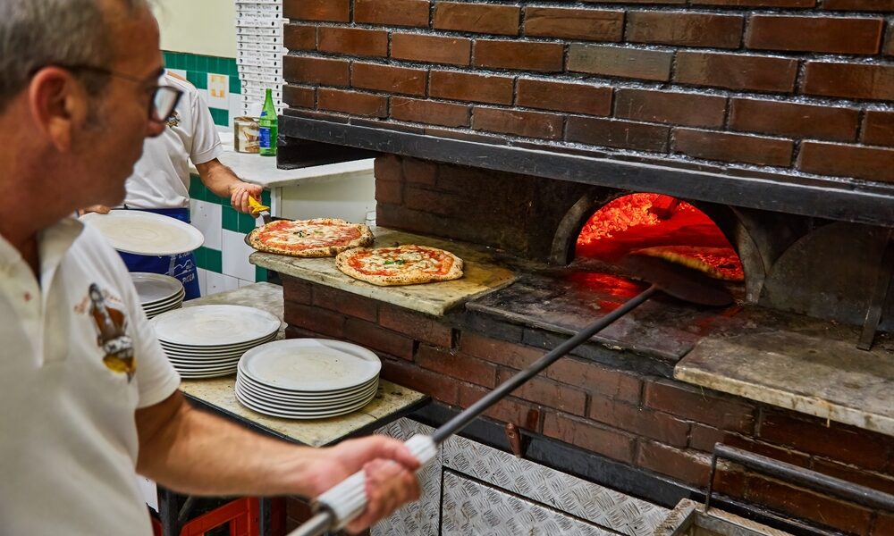 L'Antica Pizzeria da Michele. Naples pizzeria. Naples, Italy. Man making Neopolitan pizza in a wood oven.