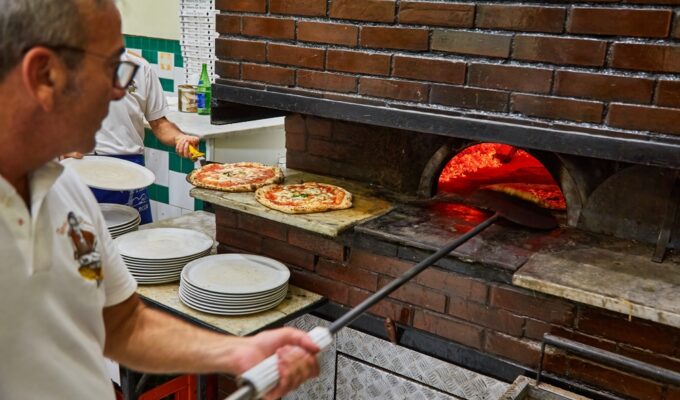 L'Antica Pizzeria da Michele. Naples pizzeria. Naples, Italy. Man making Neopolitan pizza in a wood oven.