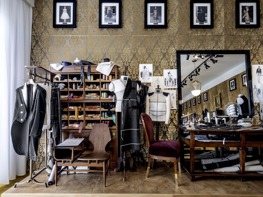 Artisans work on couture garments inside the atelier-inspired room of From the Heart to the Hands: Dolce & Gabbana at ICA Miami, highlighting Italian handmade craftsmanship and tailoring traditions.