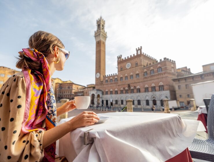 woman drinking coffee in Siena piazza