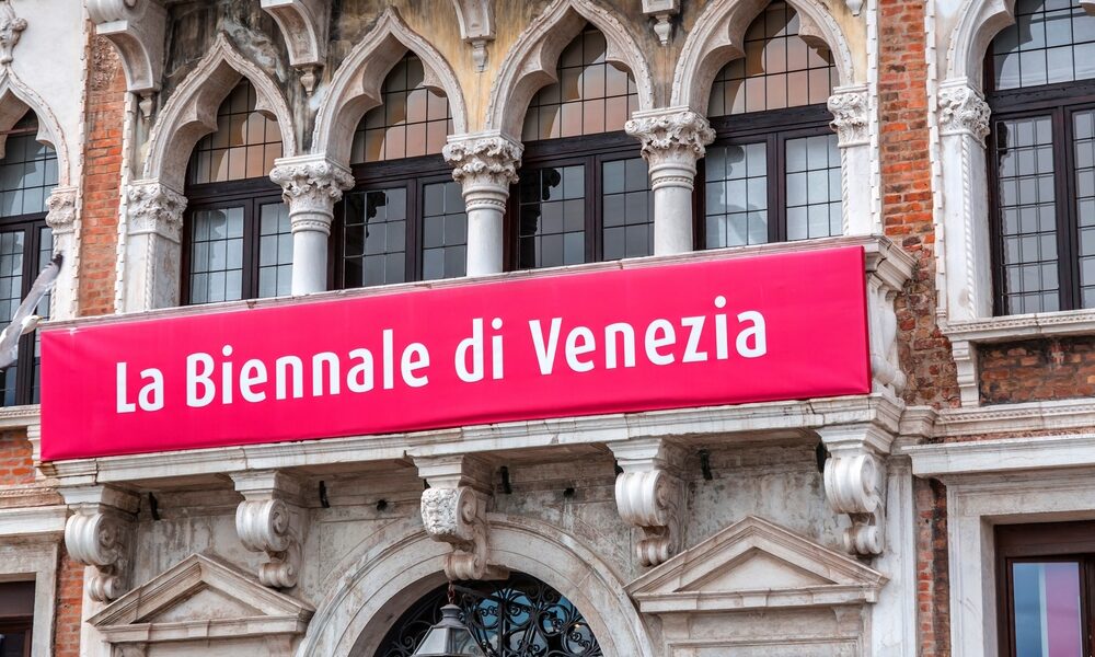 Sign of the annual Venice Biennale in Italian Language, hung on a palazzo wall.