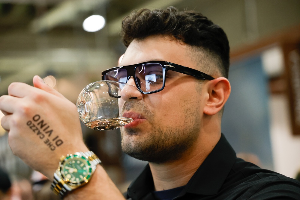 A visitor tastes Italian white wine during Vinitaly 2026, highlighting the fair’s focus on wine professionals and consumers.