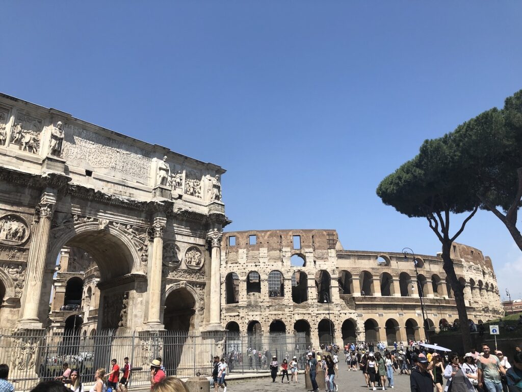 View of the Colosseum and Arch of Constantine in Rome on a sunny summer day.