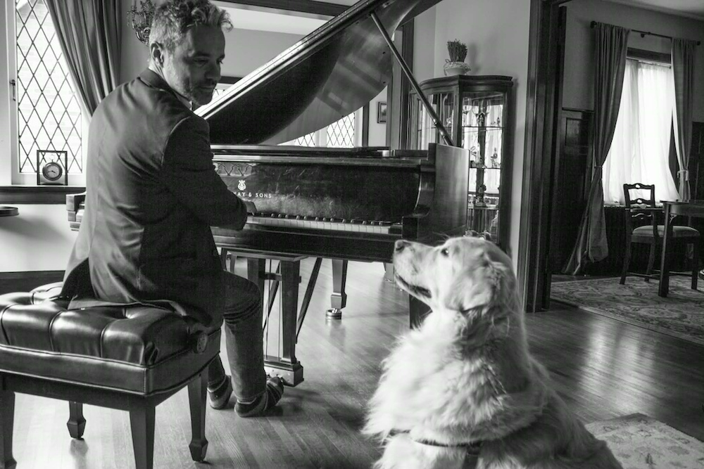 Luigi playing the piano at home in Abruzzo with his dog by his side