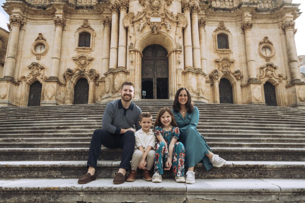 Angela Isherwood with her husband and children in Modica, Sicily, on the island of Sicily, connected to her family heritage and personal history.