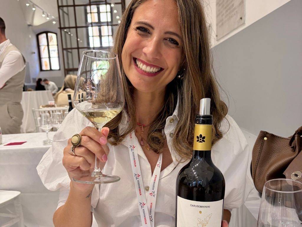 Wine tasting with a glass of Sicilian white wine and a bottle of Caruso & Minini Perluci