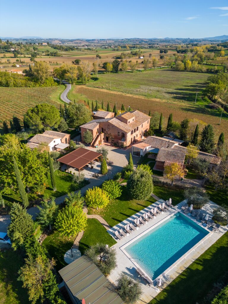 Aerial view of Borgo San Vincenzo, an elegant boutique hotel estate nestled in the Montepulciano countryside and accommodation site for Total Tuscany retreats.