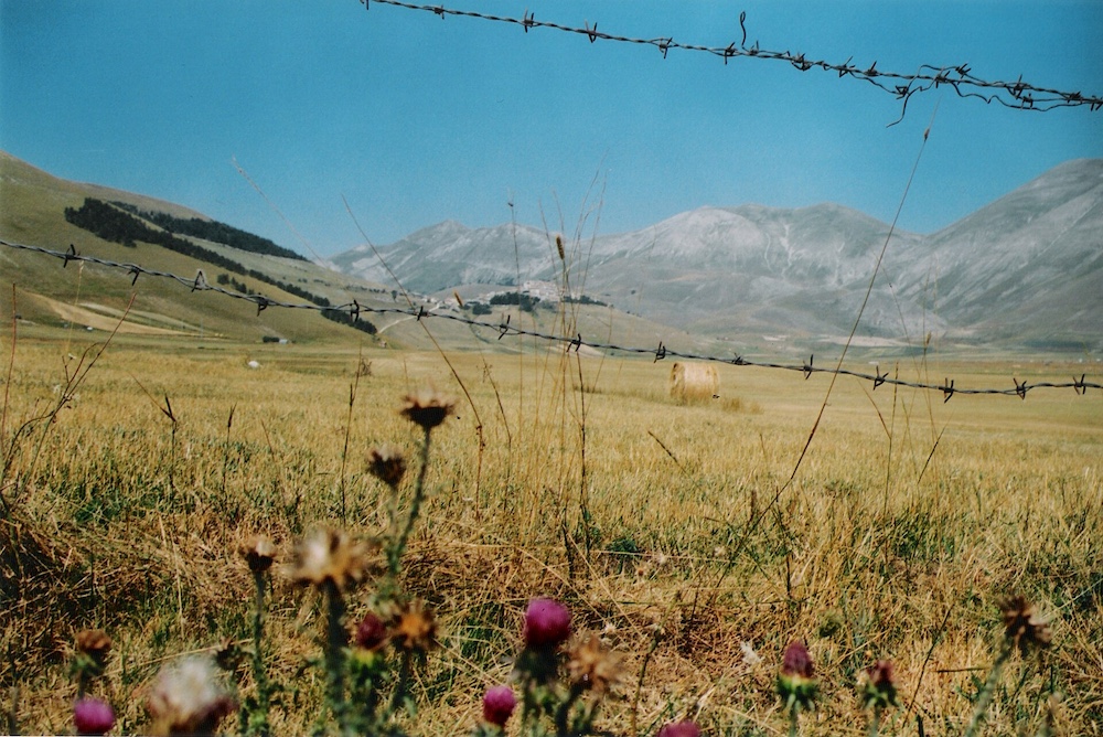 Panoramic view of Castelluccio di Norcia and the surrounding Apennine Mountains in Umbria, Italy.