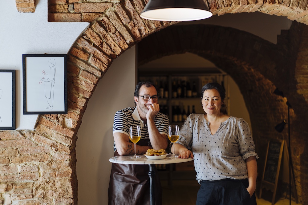 Emiko Davies and her husband Marco at Enoteca Marilu in San Miniato, Tuscany, with glasses of natural wine.
